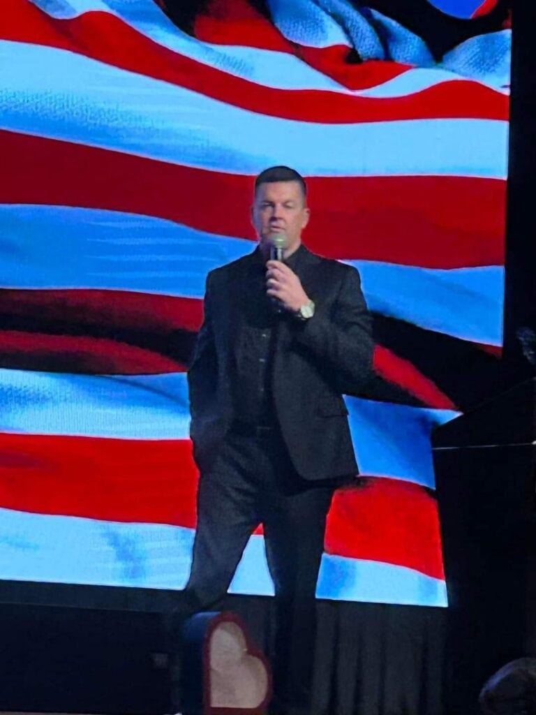 J.J. Carrell speaking on a stage.